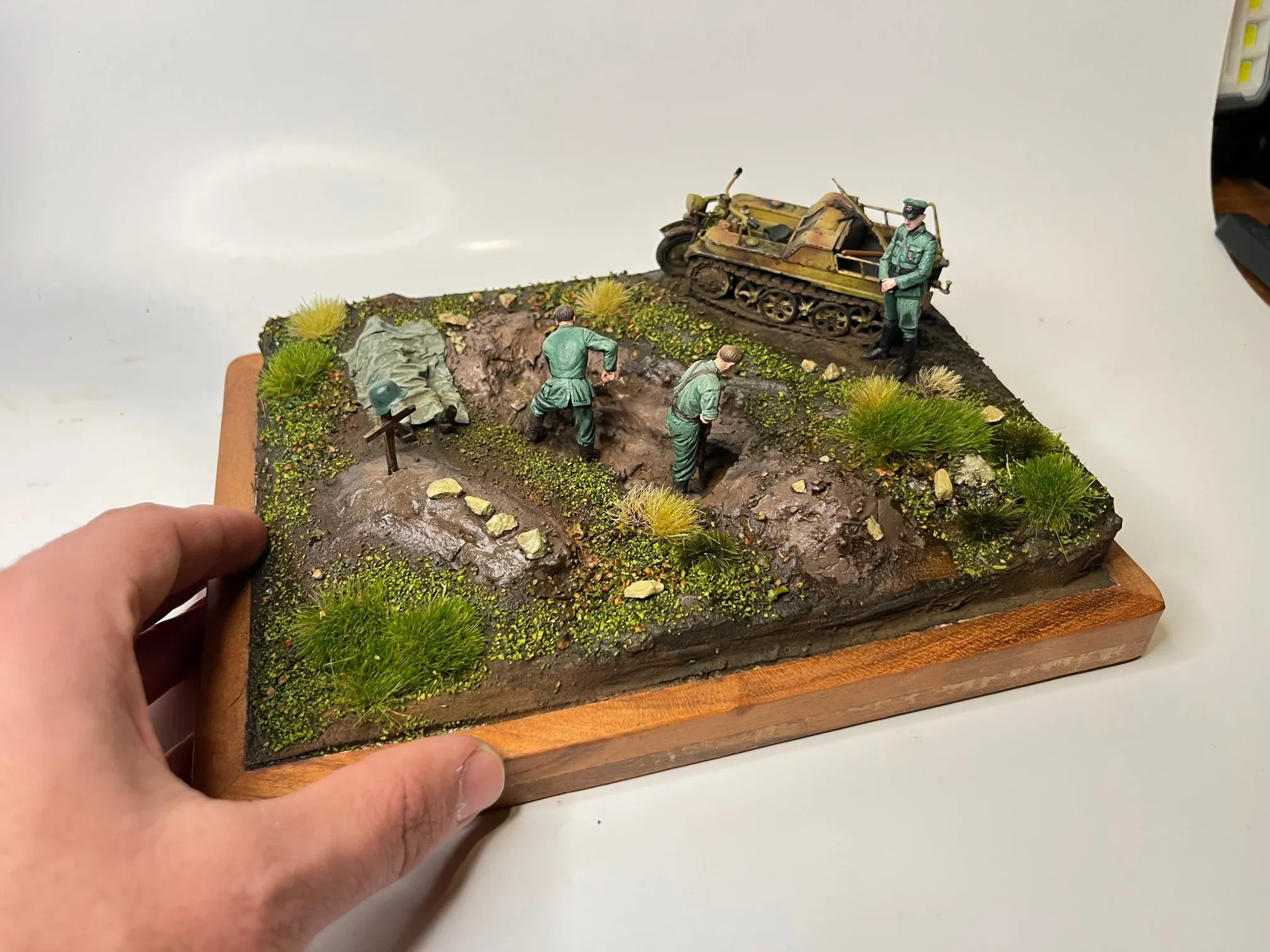Petit diorama tenu en main : un char léger et des fantassins sur un terrain herbeux