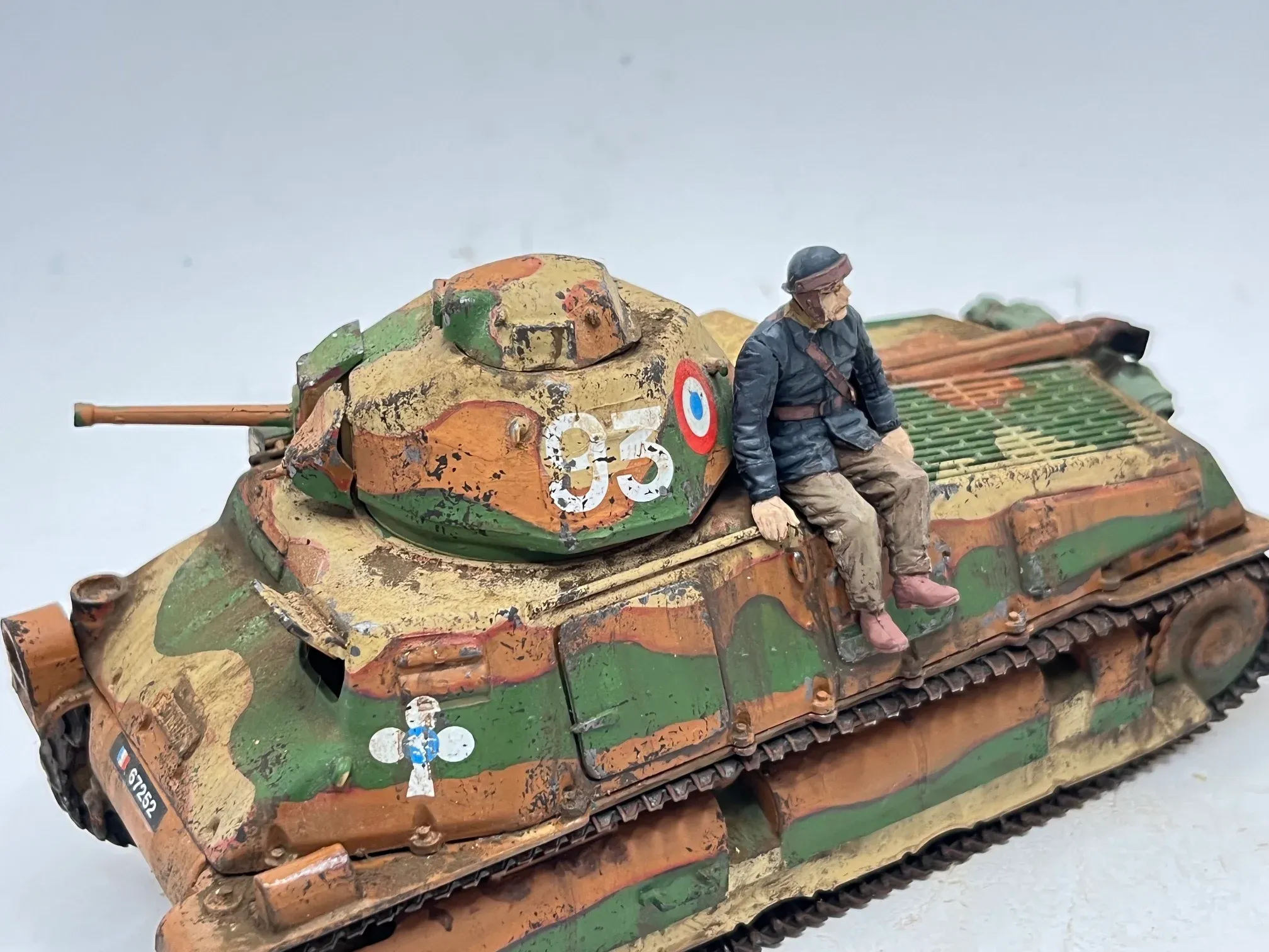 Maquette d’un char Somua S35 au camouflage ocre, vert et brun, un tankiste assis sur la caisse
