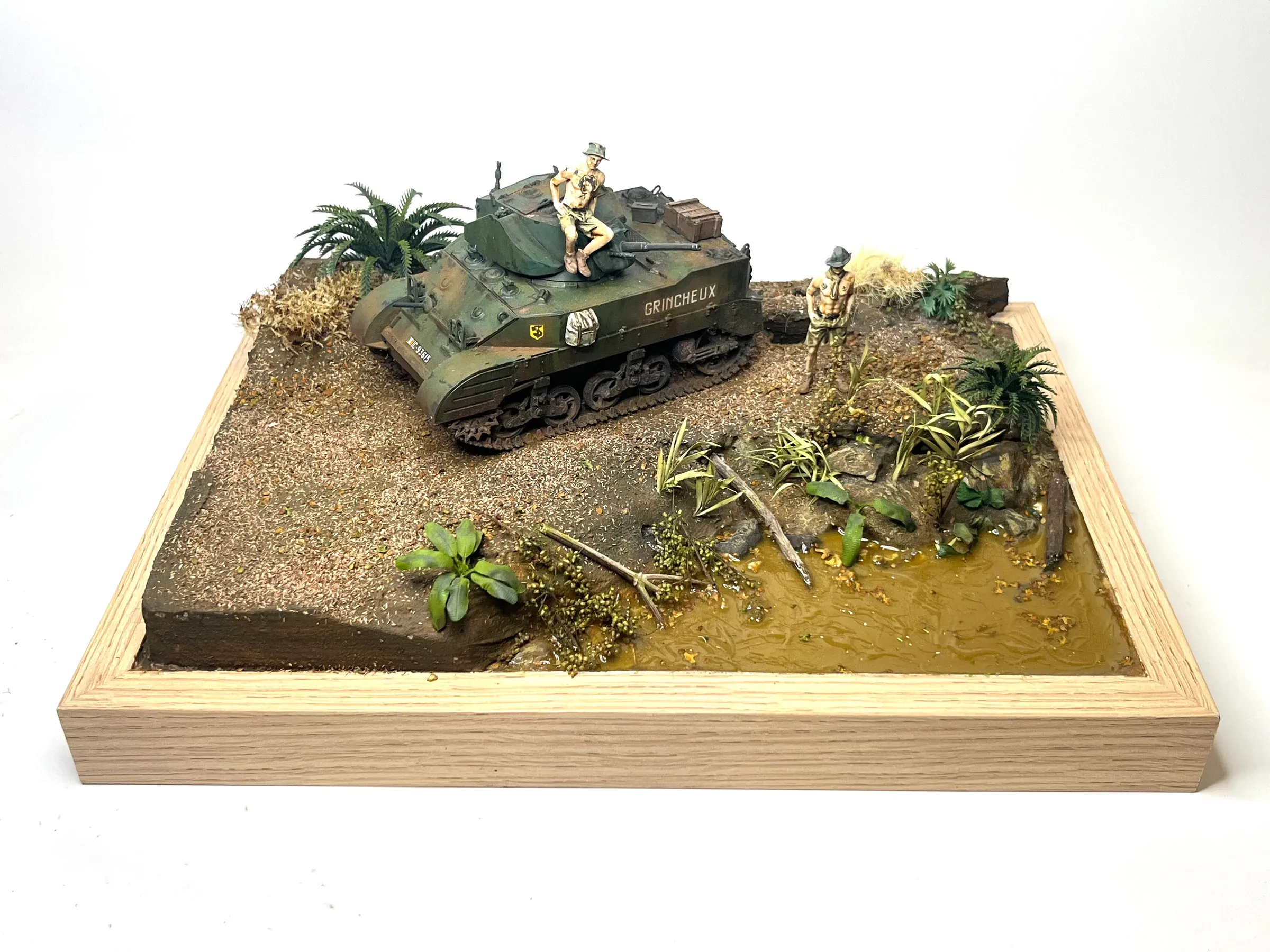 Diorama : un char léger et des soldats au milieu de la végétation tropicale, sur un socle de bois clair