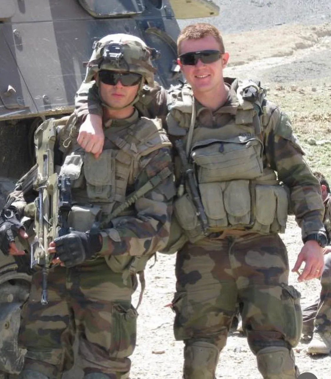 Photo de terrain : deux jeunes soldats français en tenue camouflée, casque et lunettes de soleil, posent côte à côte en souriant