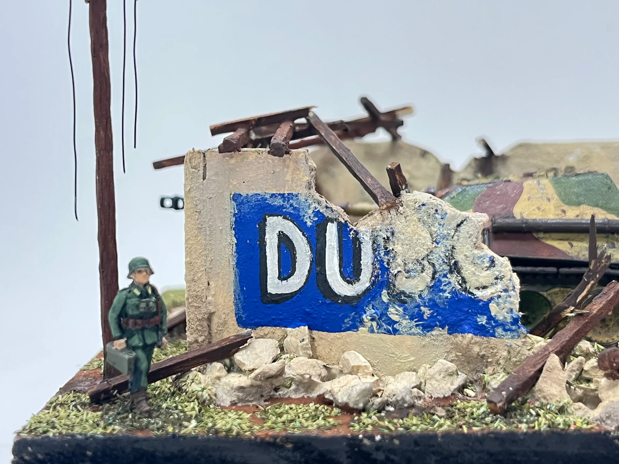 Détail : un soldat devant le mur en ruine et sa réclame bleue