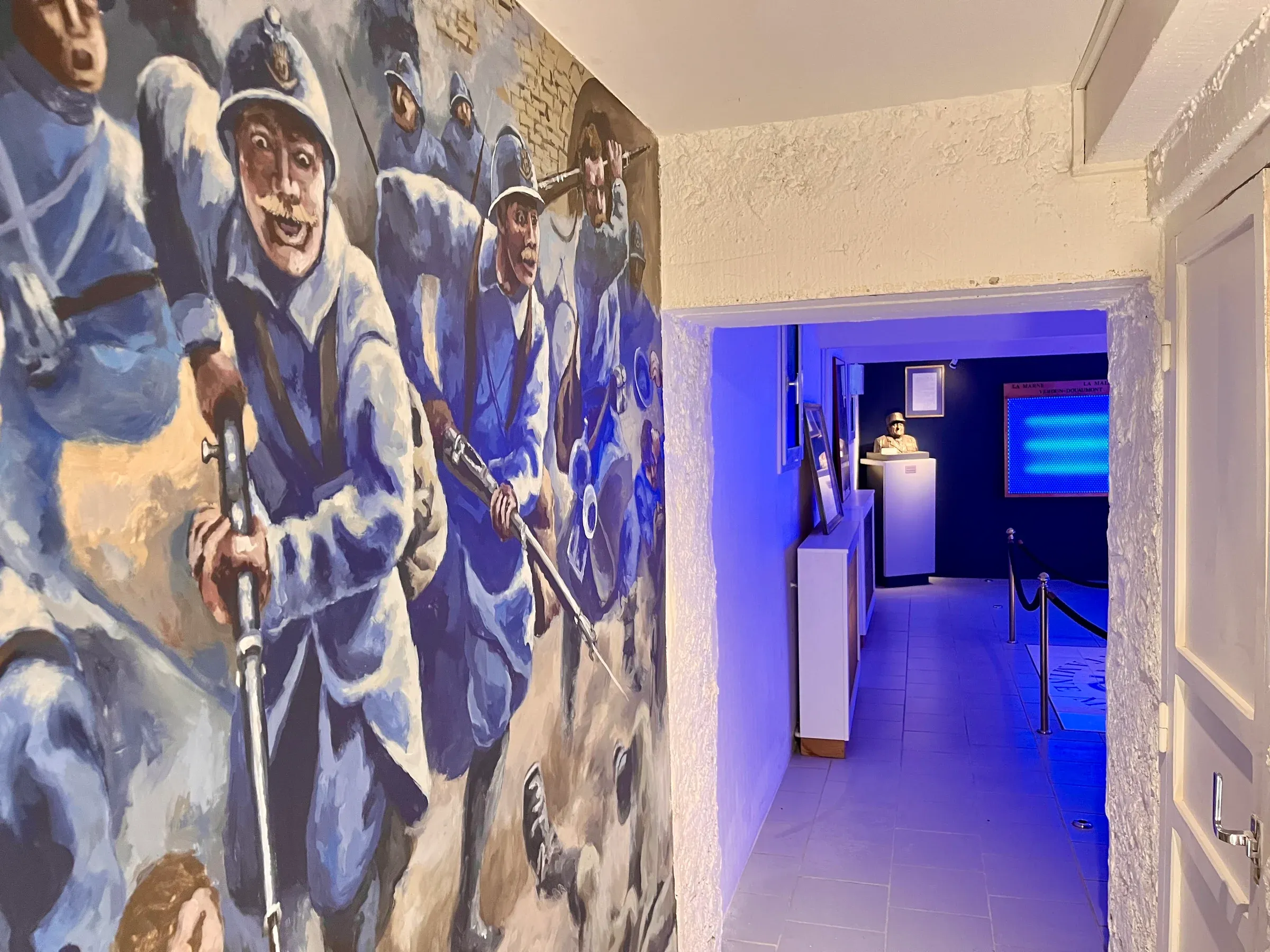 La fresque dans son couloir, ouvert sur une salle d’exposition éclairée de bleu